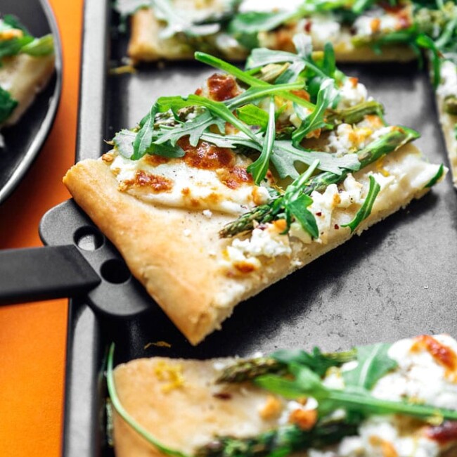 Asparagus pizza recipe on orange background - This Burrata Asparagus Pizza is a simple yet downright delicious flatbread to whip up on pizza night. Creamy burrata piled with tender asparagus, fresh arugula, and lemon!