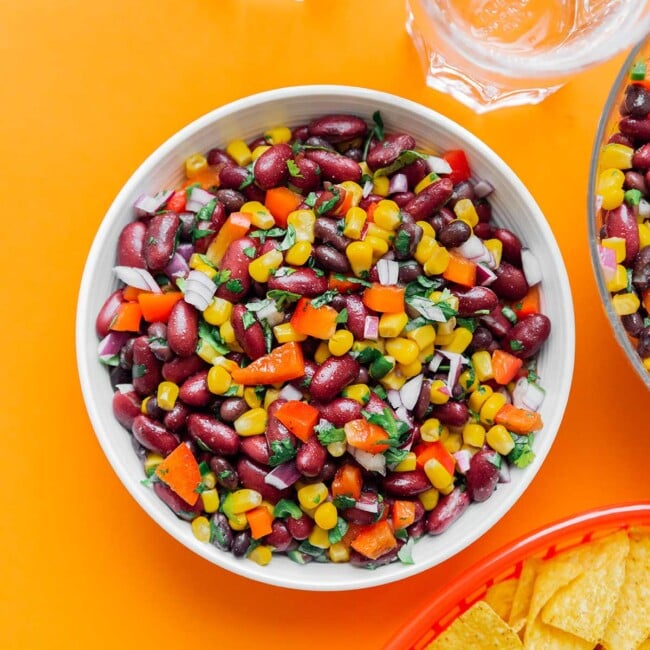 Bean salad in a bowl on an orange background