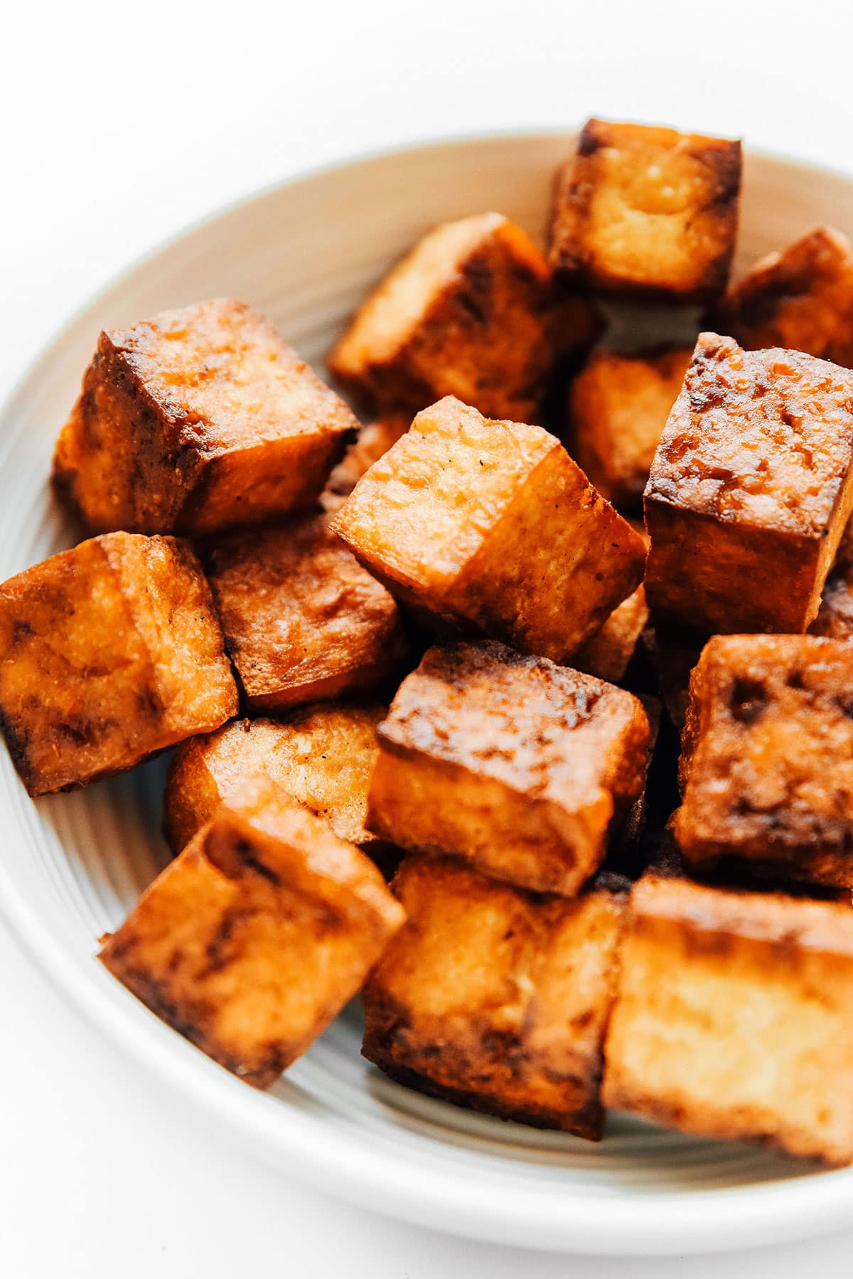 Blocks of crispy tofu in a bowl.