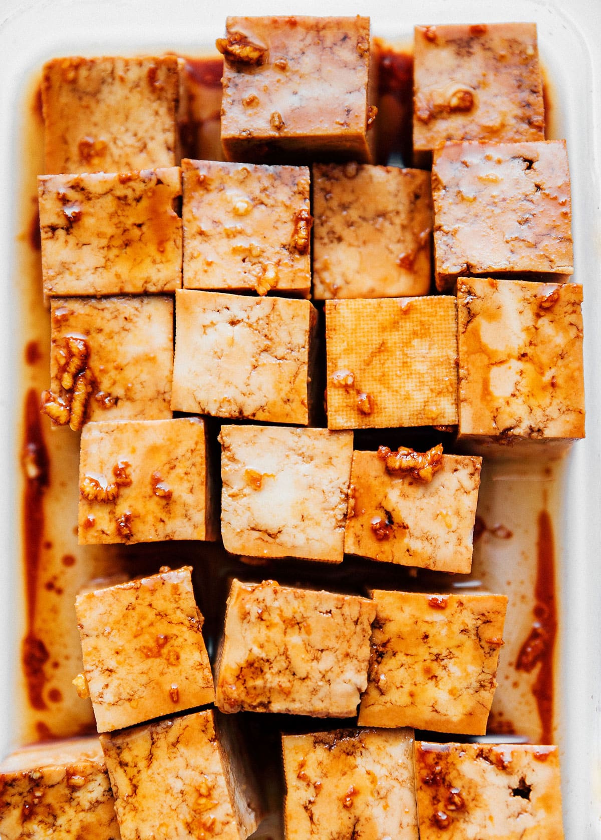 Marinating tofu in a container.