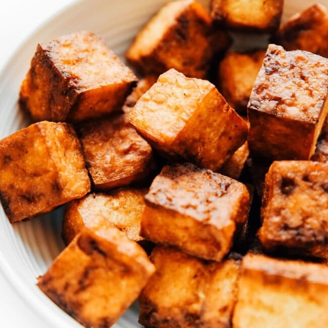Crispy tofu recipe in a white bowl - This vegan air fried tofu tastes like it's straight from the deep fryer (while being way lower in fat).