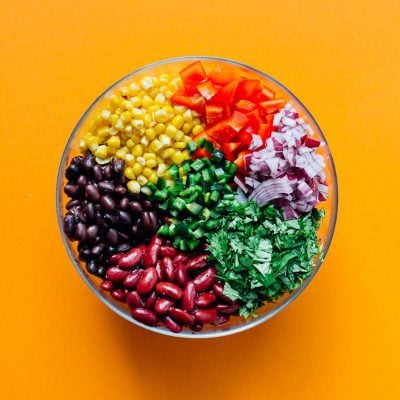 Bean salad in a bowl on an orange background