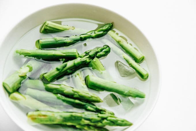 Boiled asparagus recipe on white background - The ultimate guide on how to cook asparagus! How to cook asparagus in the oven, in the microwave, or by blanching, steaming, or sautéing.