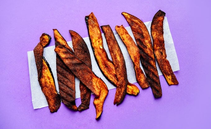 Vegan eggplant bacon recipe on purple background - This vegan Eggplant Bacon recipe takes all the flavor and crispiness of bacon and packs it into thinly sliced bacon!
