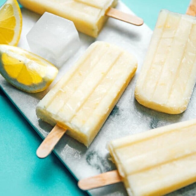 Lemon buttermilk popsicles with ice on a marble slab