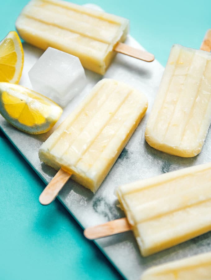 Lemon buttermilk popsicles with ice on a marble slab