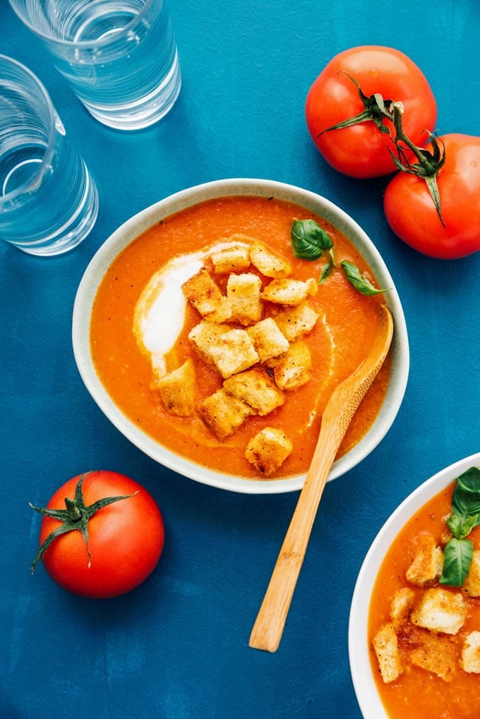 Fresh tomato soup in a  bowl with homemade croutons and roma tomatoes
