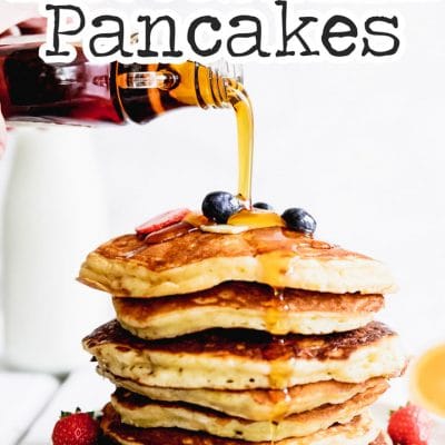 Stack of the best buttermilk pancakes with berries on a white background.