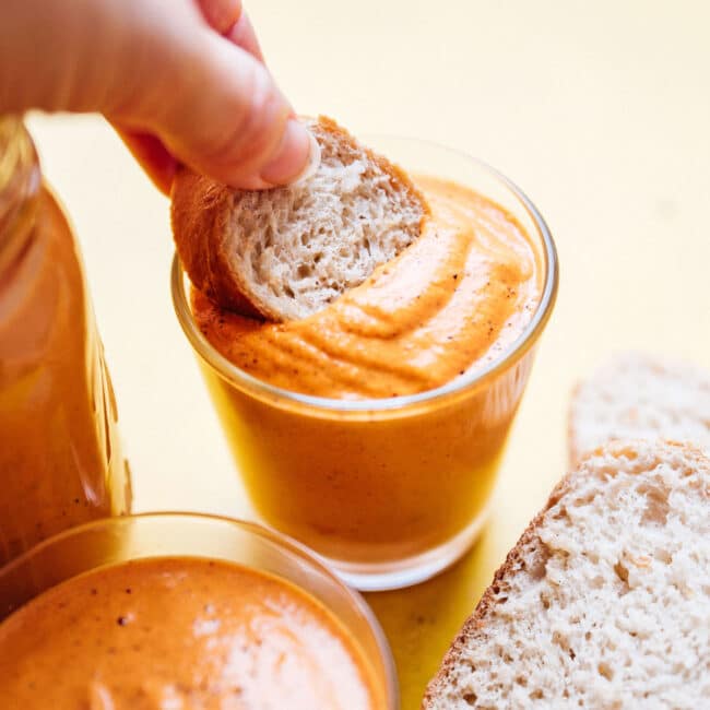 Romesco sauce recipe in a jar with a spoon.