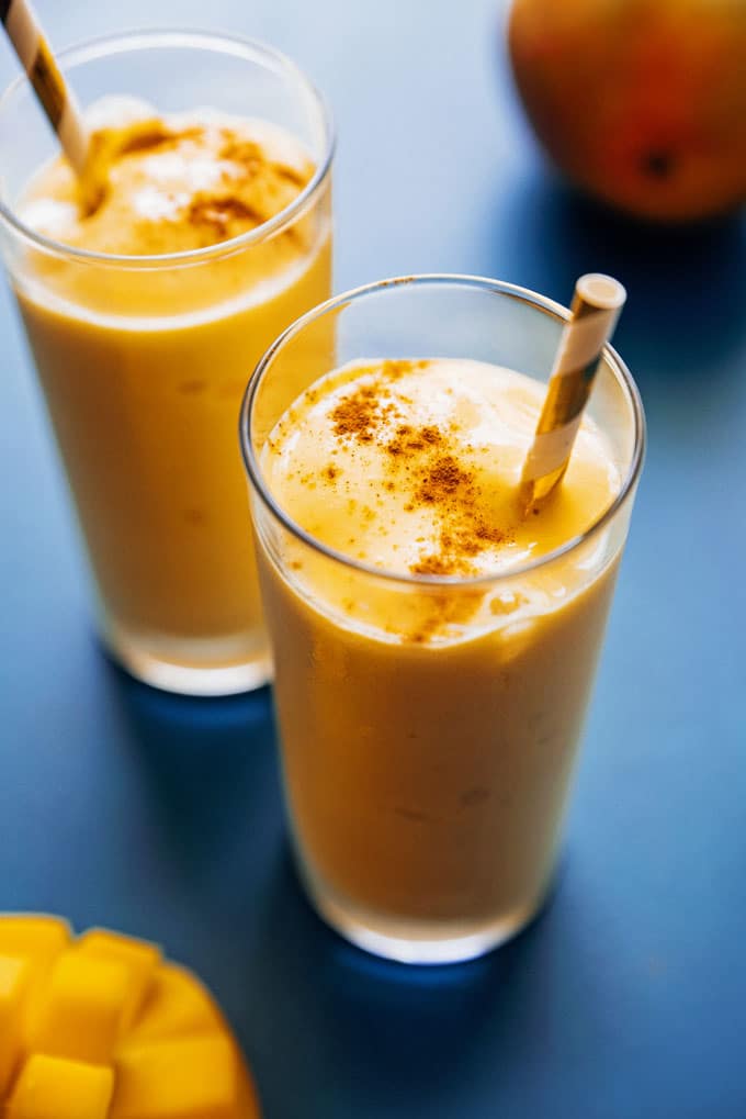 Close up of mango lassi in a glass with a straw