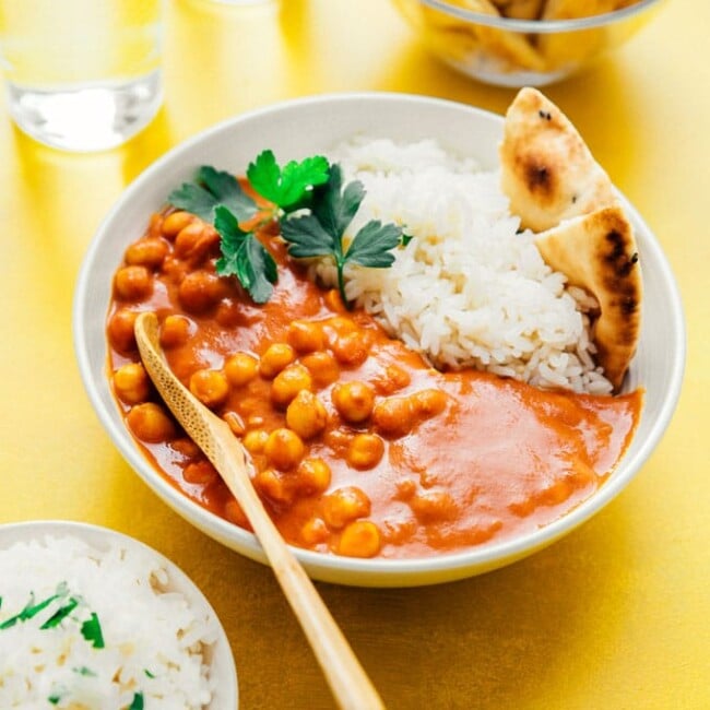 Vegan tikka masala with naan and rice in a white bowl