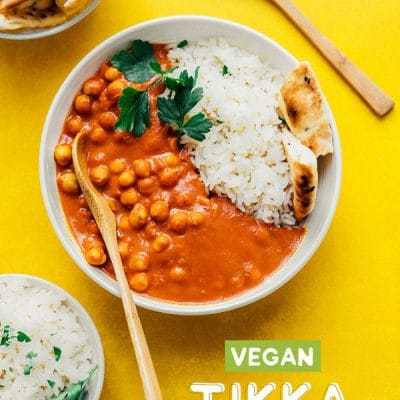 Chickpea tikka masala with naan and rice in a white bowl
