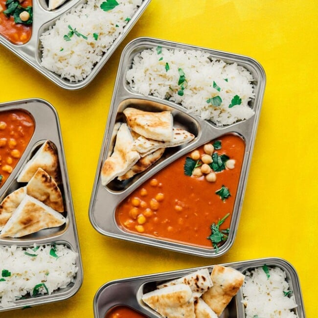 Vegan tikka masala with naan and rice in meal prep containers
