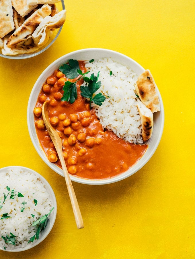 Vegan tikka masala with naan and rice in a white bowl