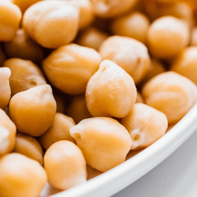 Close up photo of chickpeas in a white bowl