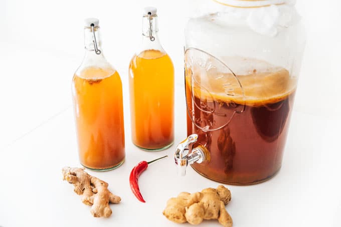 Ginger kombucha in fermentation bottles with SCOBY jar