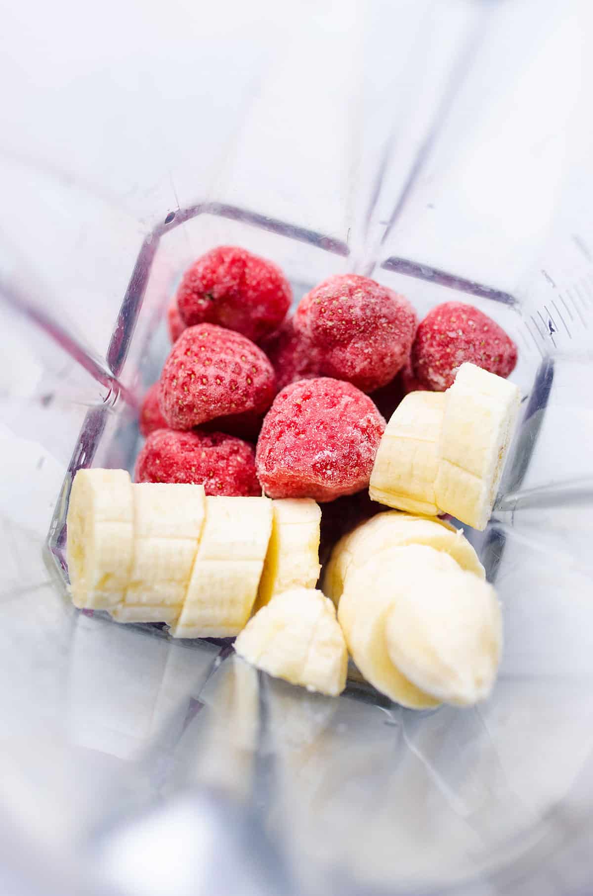 Frozen strawberries and bananas in a blender.