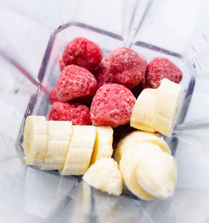 Ingredients for strawberry banana smoothie in a blender