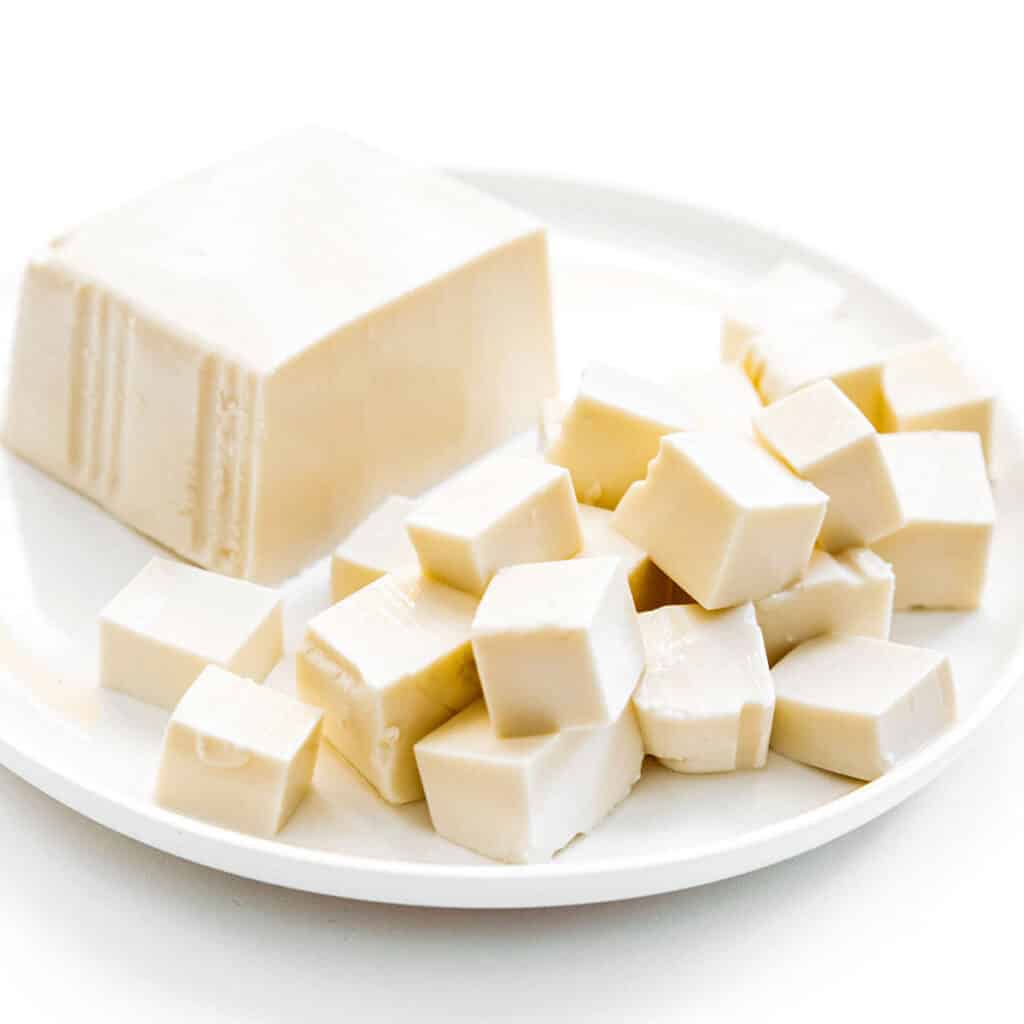 Bock of silken tofu and cubes of tofu on a white plate