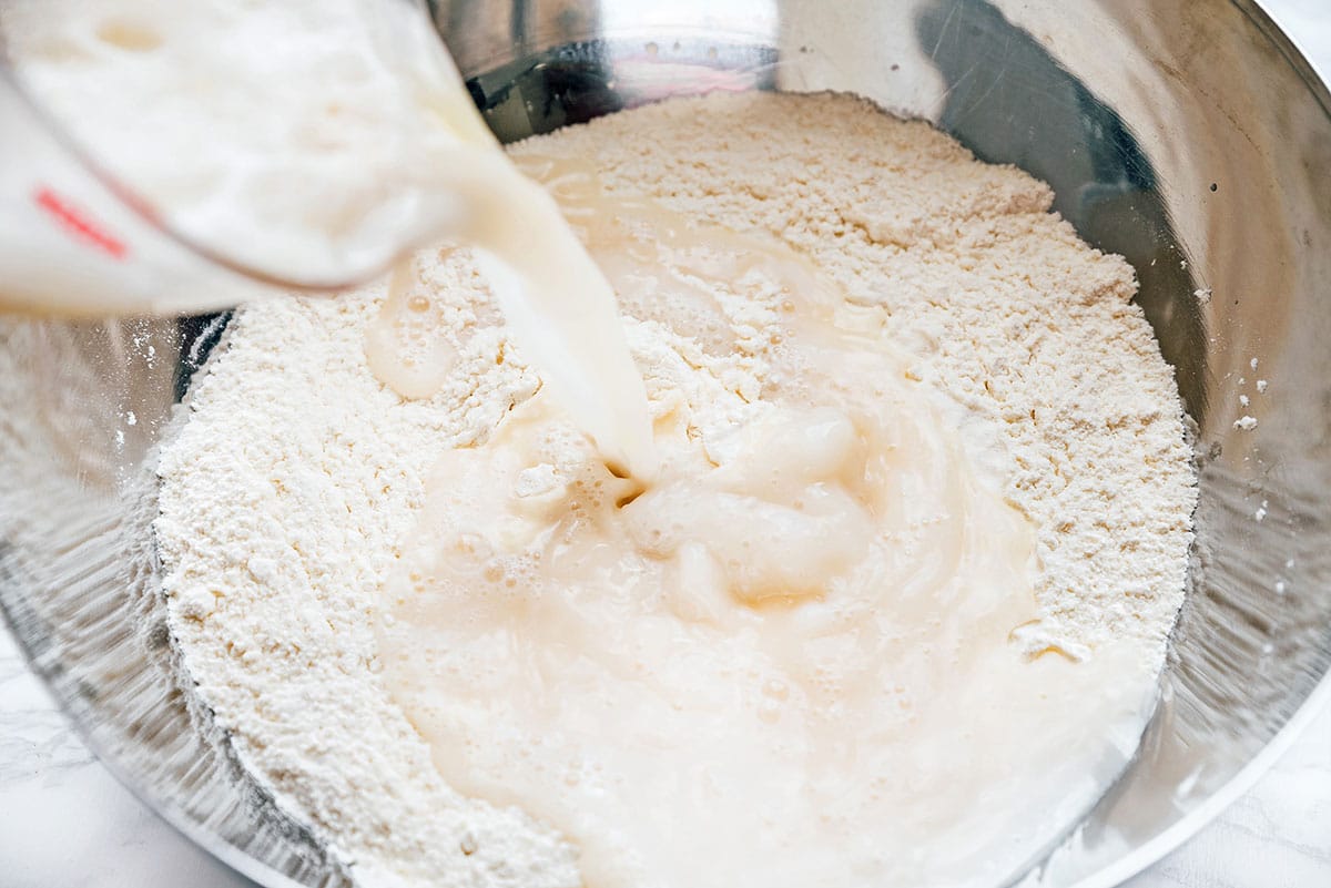 Mixing wet ingredients into dry ingredients for pizza dough.