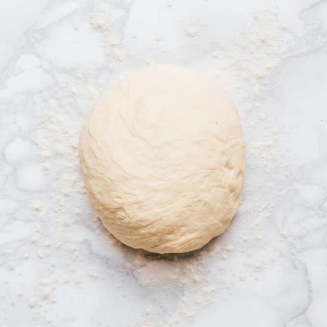 Kneaded pizza dough on a marble background