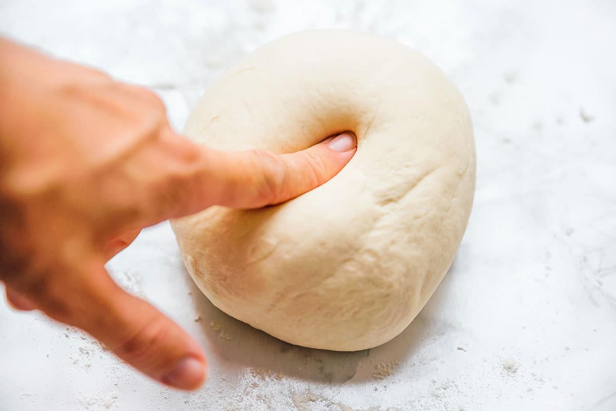 Finger poke test for pizza dough.