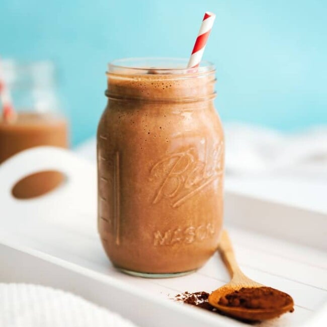 Tofu mocha smoothie in a glass with blue background