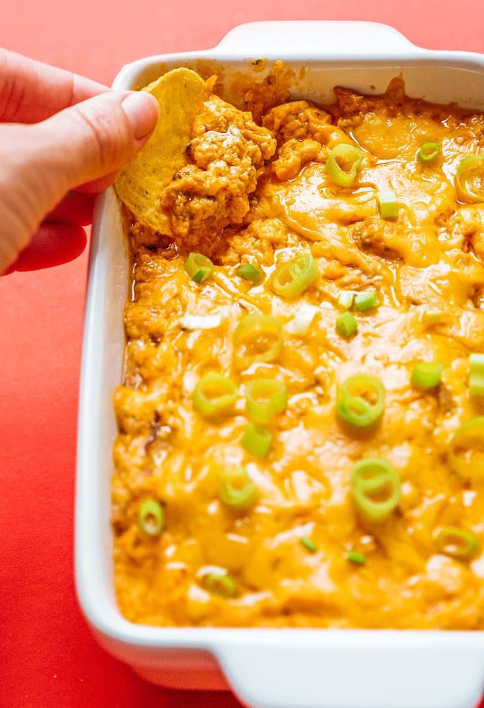 Scooping vegetarian franks buffalo chicken dip with a chip