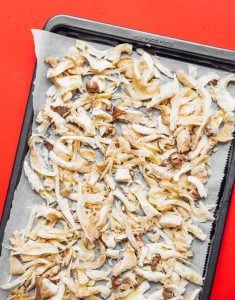 Shredded king oyster mushrooms on a pan