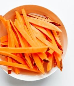 Soaking sweet potato fries in water to remove starch