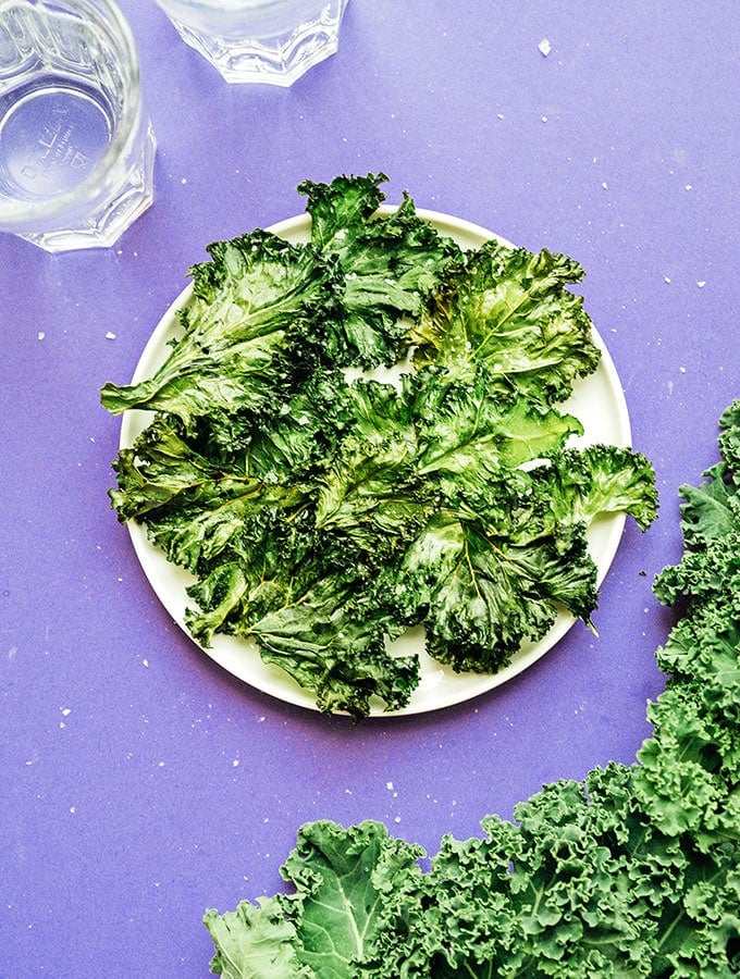 Plate of kale chips on a purple background