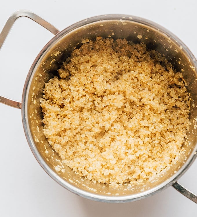 Cooked quinoa in a pan on a white background