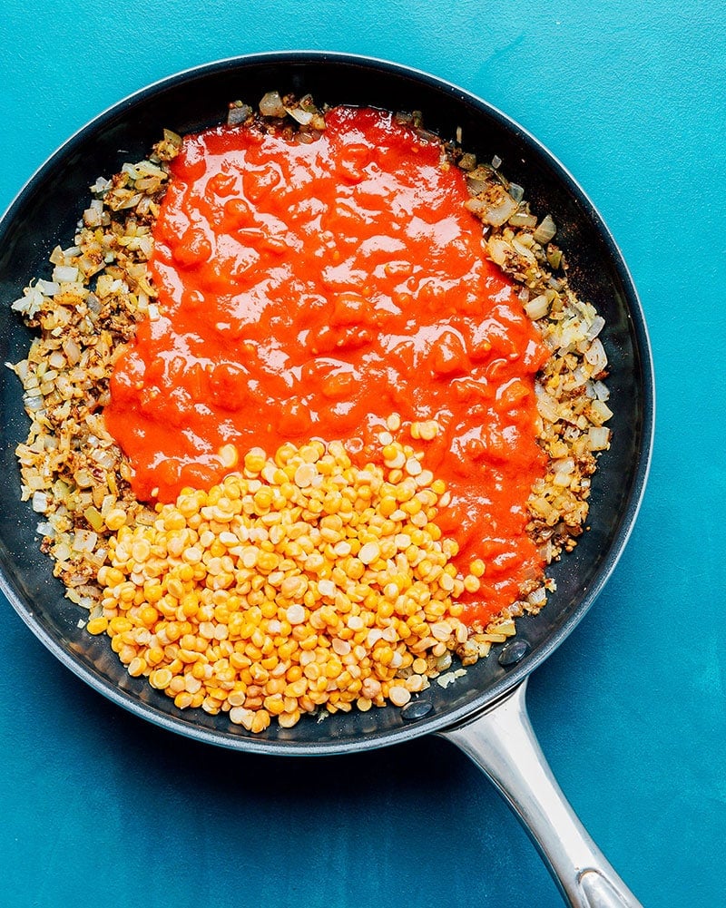 Chana dal ingredients in a skillet on a blue background