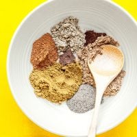 Ingredients to make garama masala on a yellow background