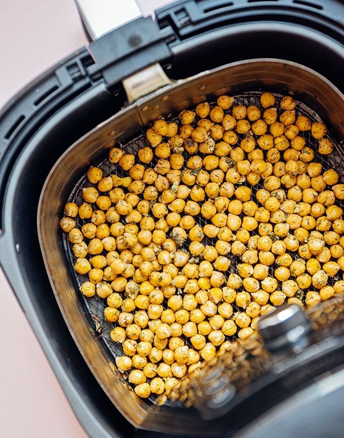 Seasoned chickpeas line the tray of an air fryer