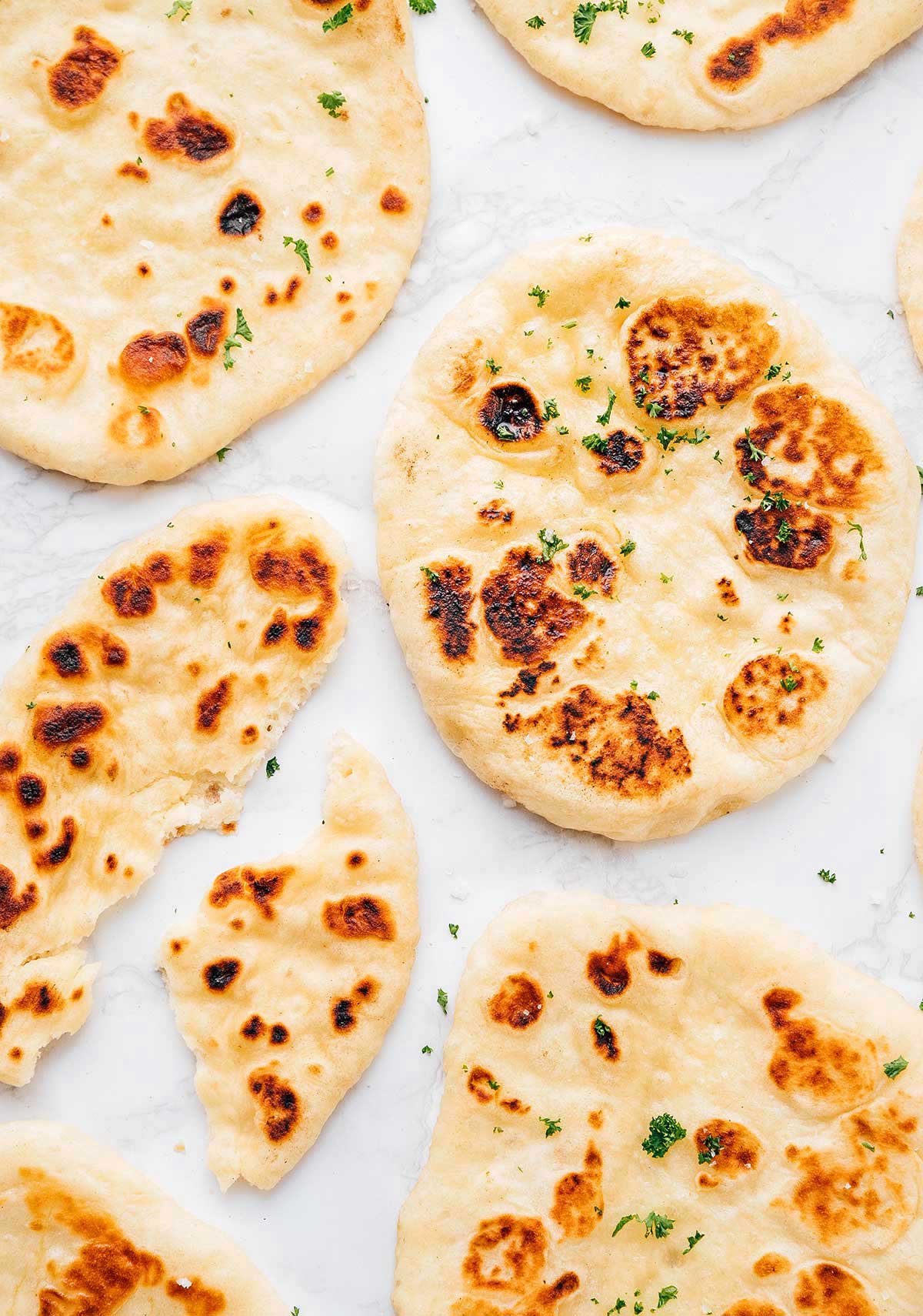 Naan bread slices laid out flat on a white background