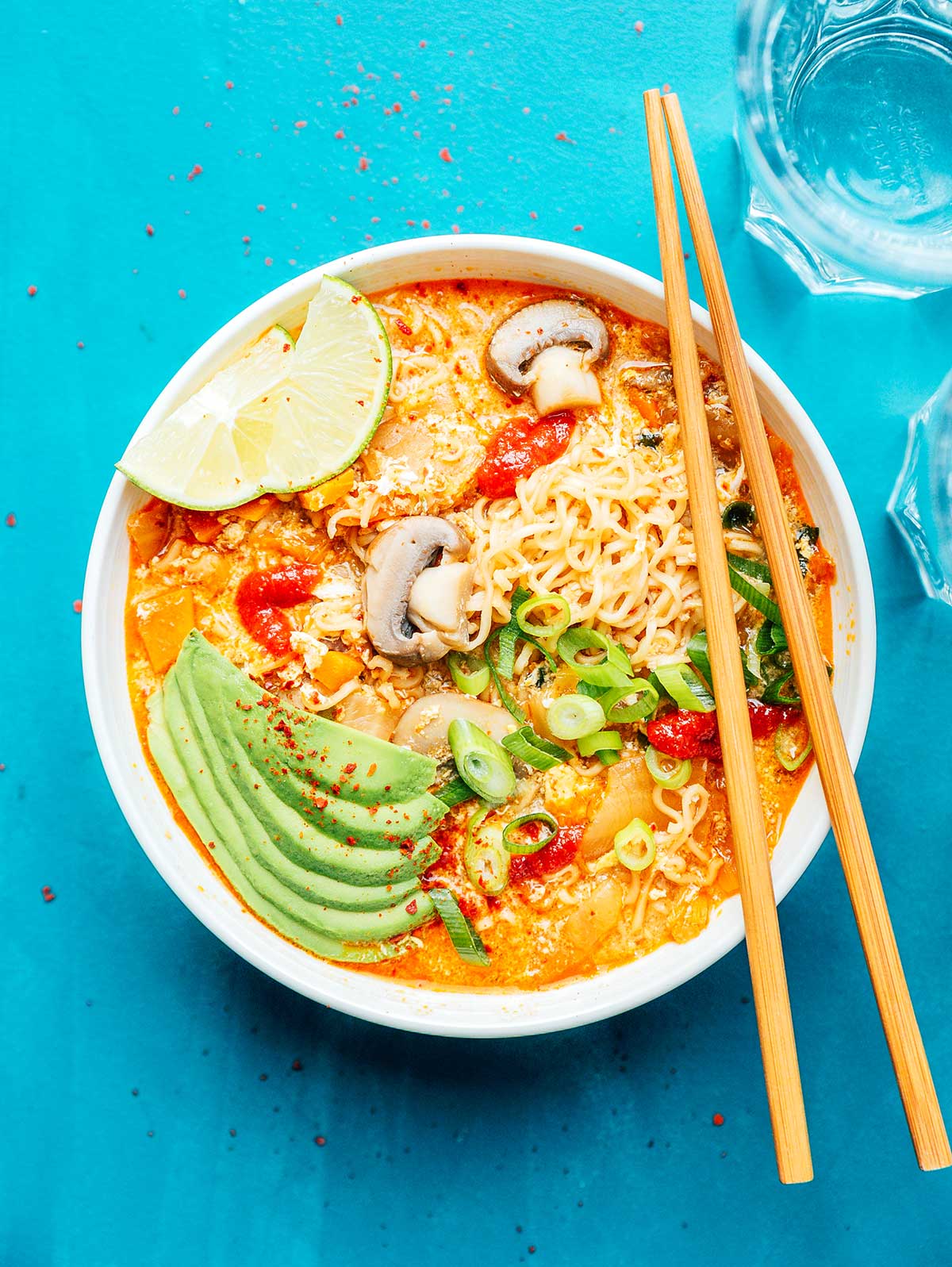 Bowl of kimchi ramen loaded with toppings on a blue background