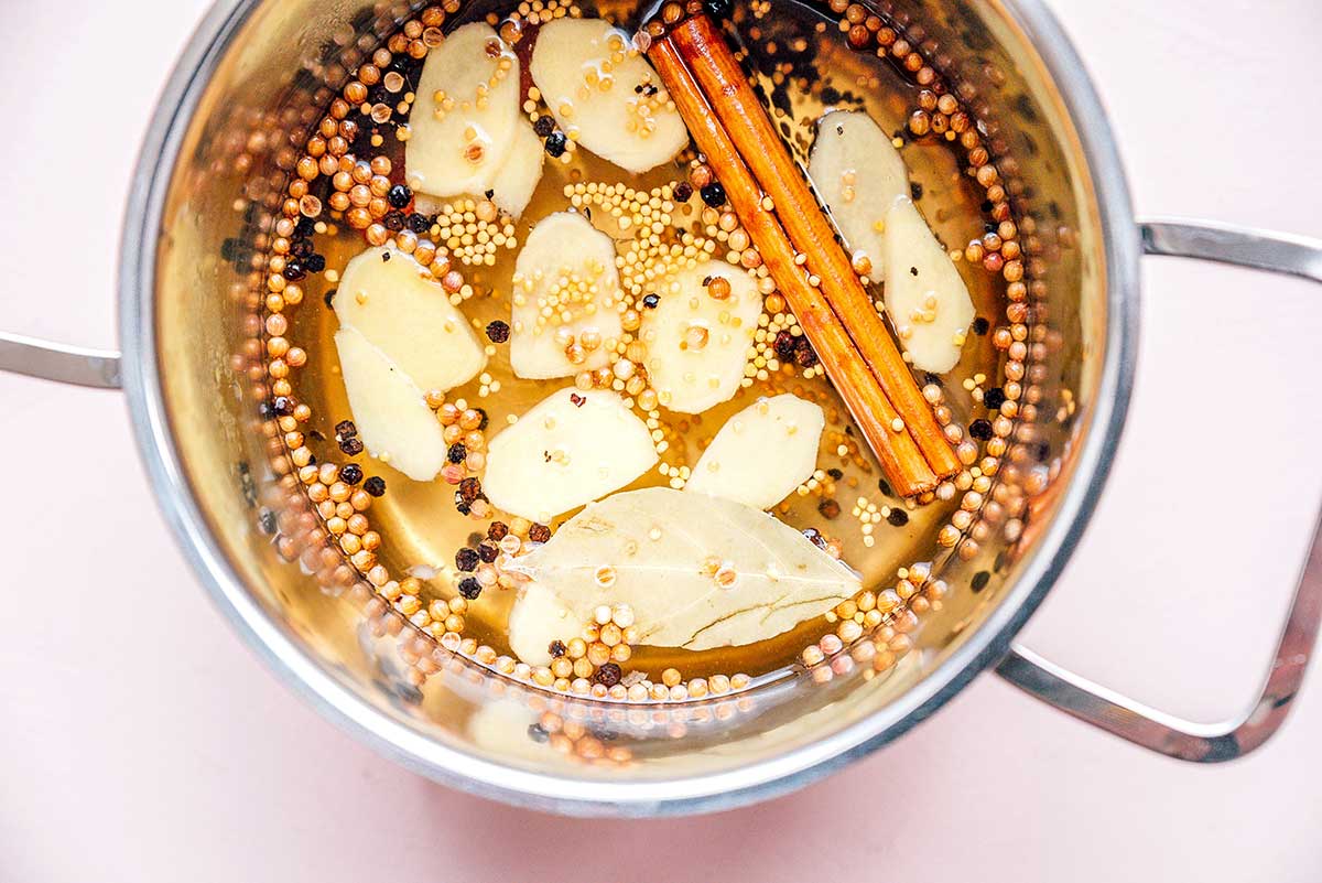 A pot filled with hot water and apple cider vinegar mixed together to aide in pickling grapes