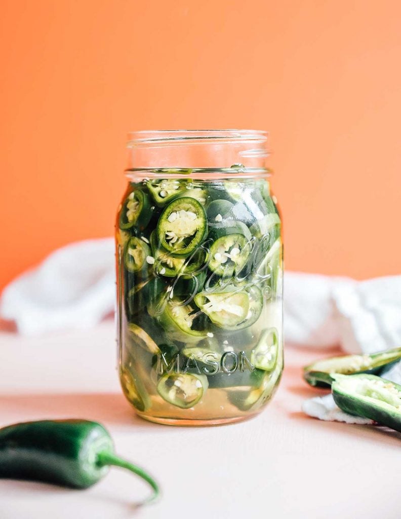 A mason jar filled with pickled jalapeños