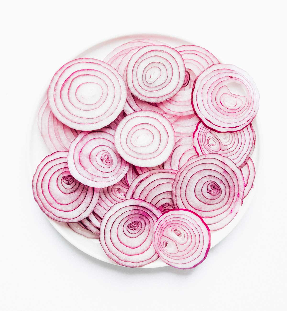A white plate filled with slices of red onions