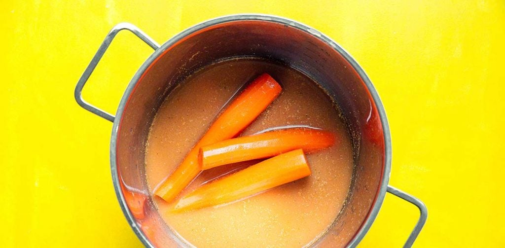 A pot filled with carrots and marinade 