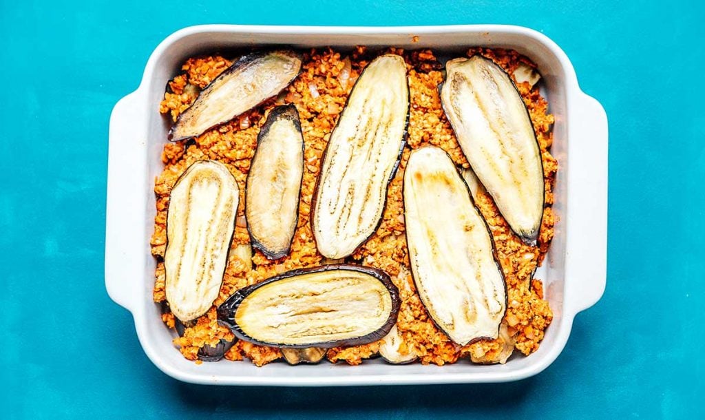 Casserole dish filled with layers of tempeh and eggplant 