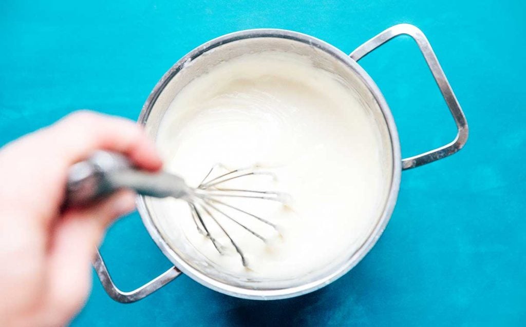Bechamel being whisked in a silver pot 
