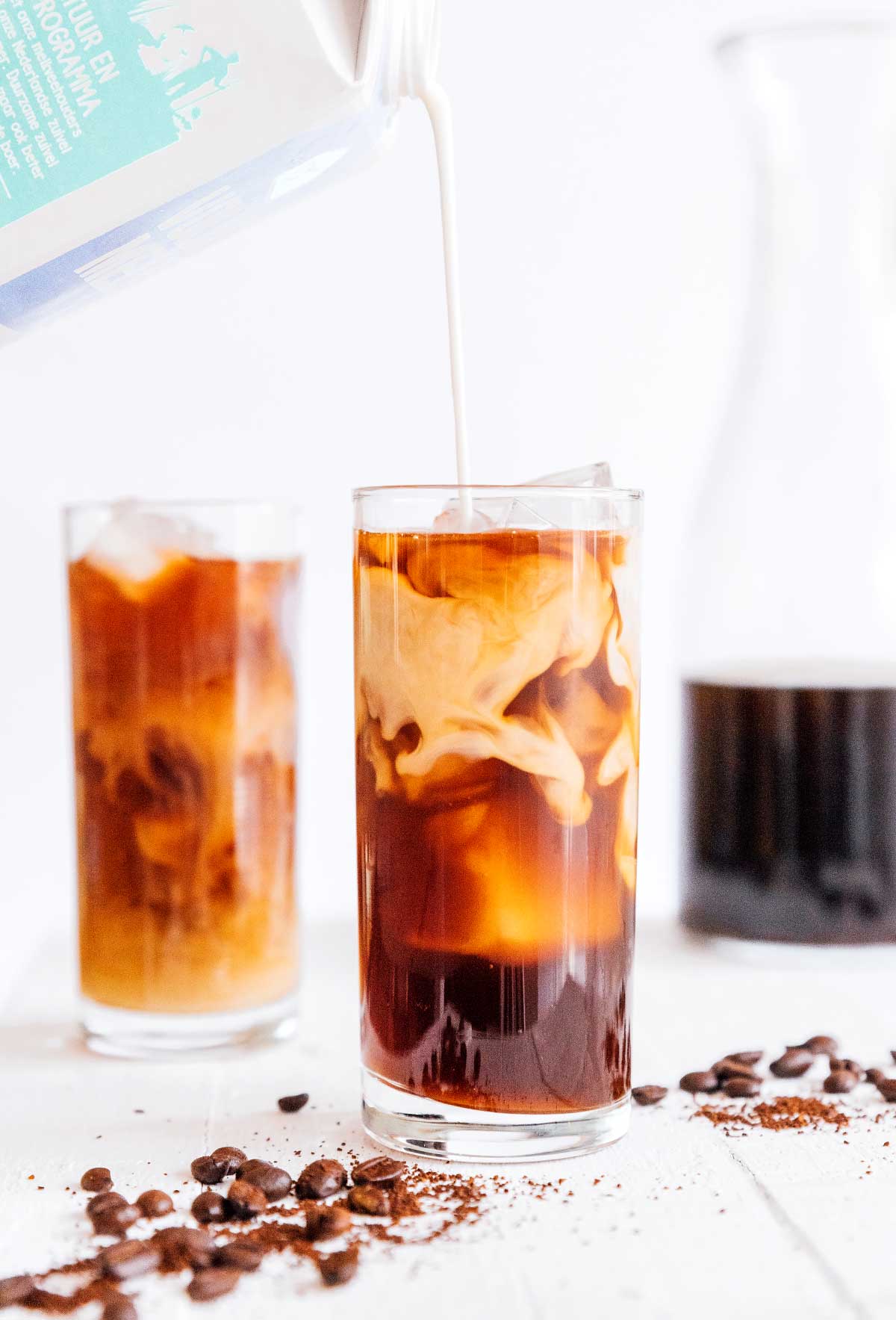 Pouring cream into a tall glass of cold brew coffee