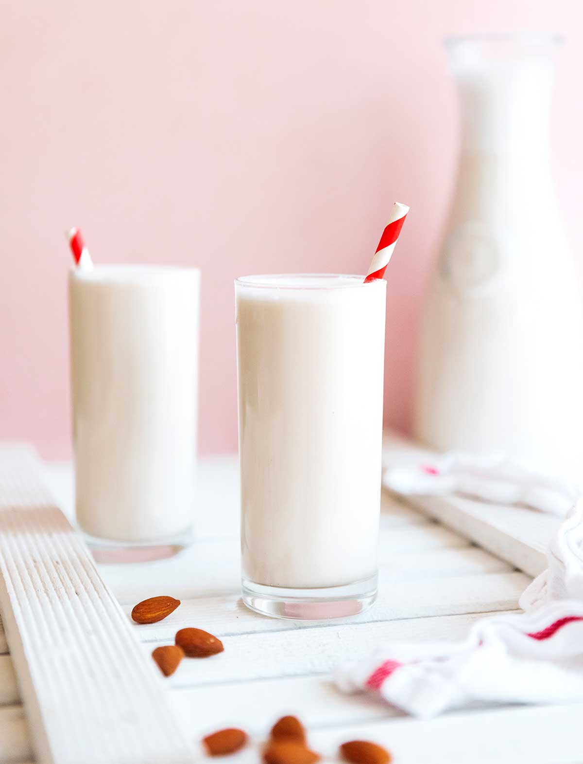 Two tall glasses filled to the brim with homemade almond milk
