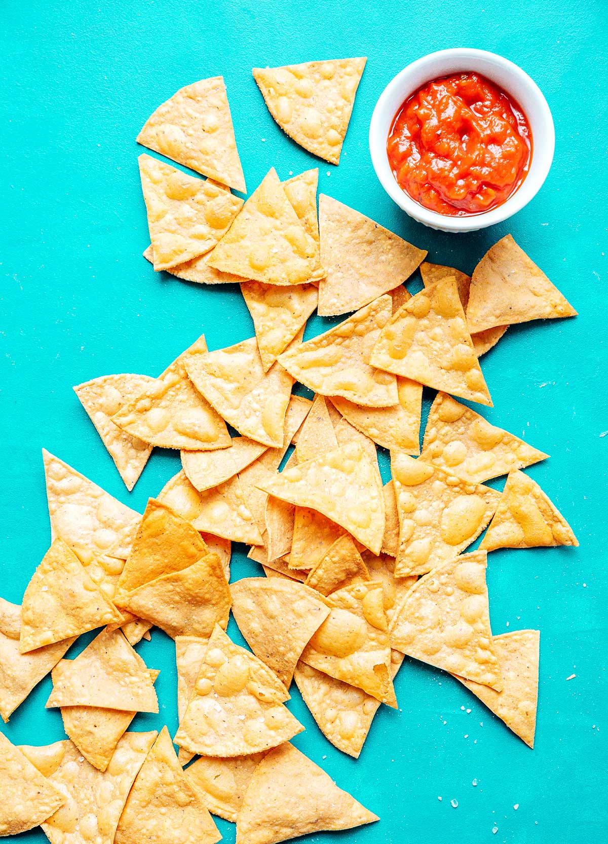 Tortilla chips on a blue background with salsa