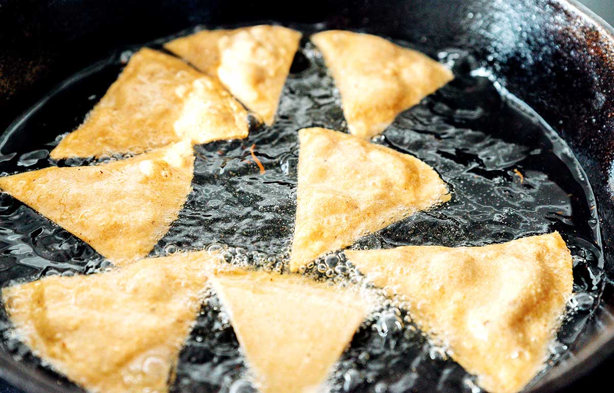 Frying corn tortilla chips in a cast iron skilelt