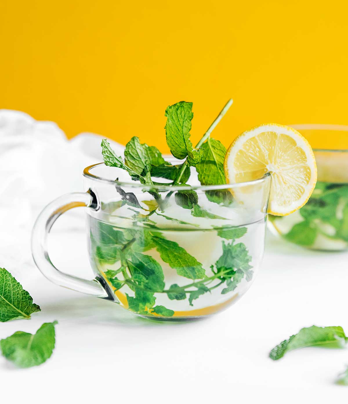 Fresh mint tea in a clear glass with a lemon
