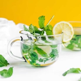 Fresh mint tea in a clear glass with a lemon