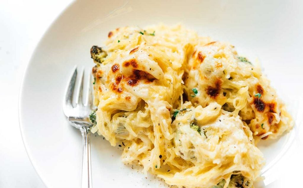 A white bowl filled with a serving of spaghetti squash Alfredo casserole